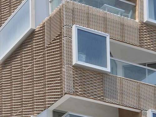 Green aluminum expanded metal meshes with diamond holes are installed on the architectural building facades by trellis.