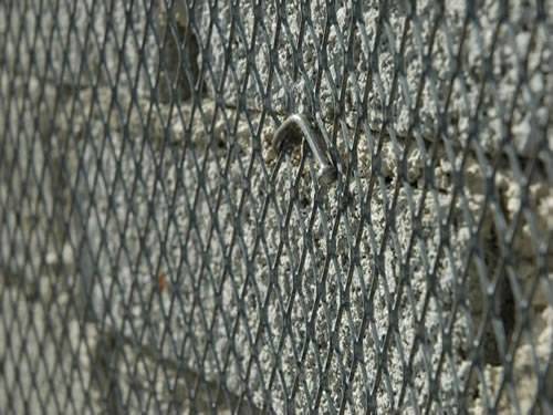 Green aluminum expanded metal meshes with diamond holes are installed on the architectural building facades by trellis.